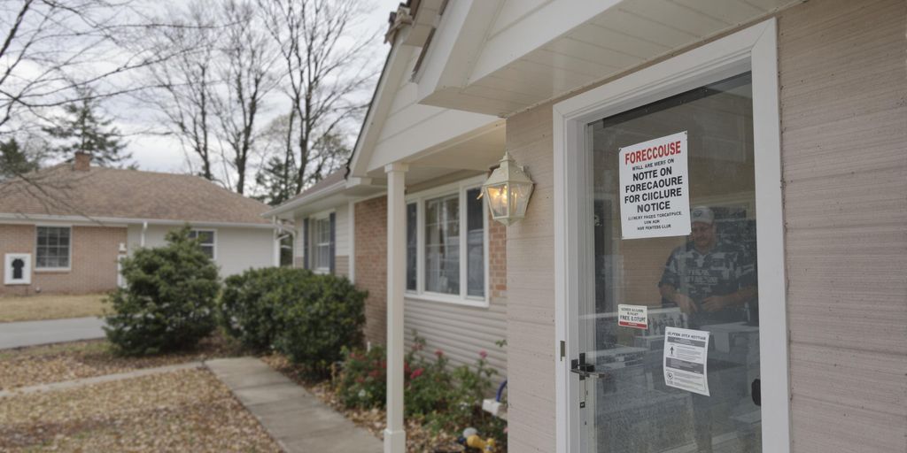 Worried homeowner outside house with foreclosure notice